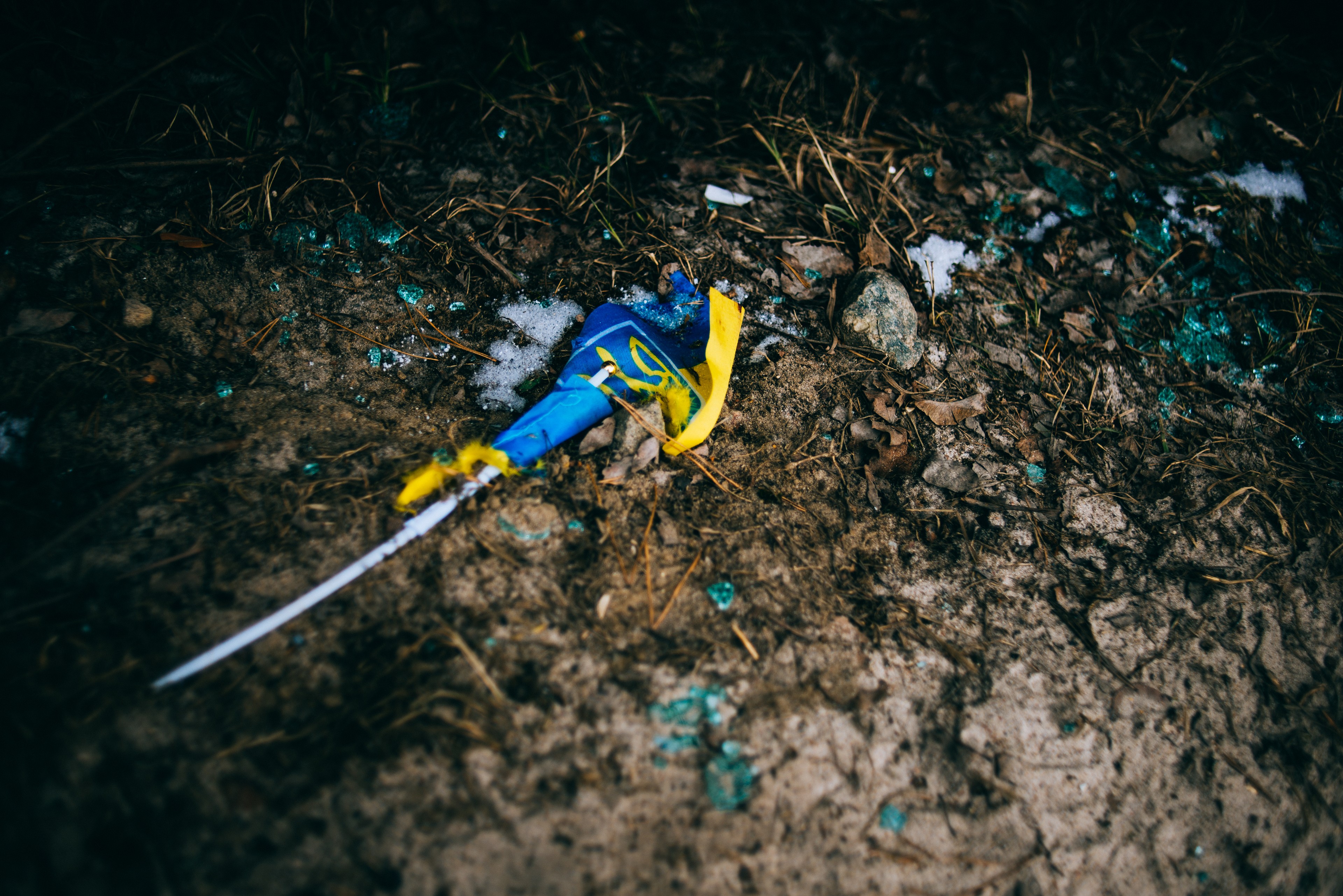 A damaged Ukrainian flag lies on the ground close to a destroyed checkpoint in Irpin.